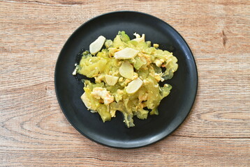 stir fried bitter cucumber with egg and slice garlic on plate