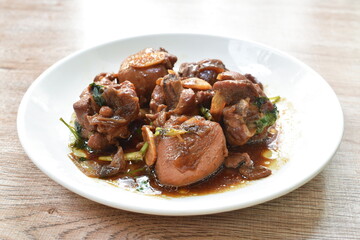 fried chicken in sweet soy sauce with slice garlic on plate