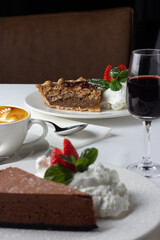 Pecan pie with fresh cream, sweet red wine and coffee