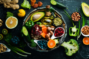 Fototapeta na wymiar Set of fruits, vegetables, berries and nuts in a wooden box. Vegan food. Top view. Rustic style.