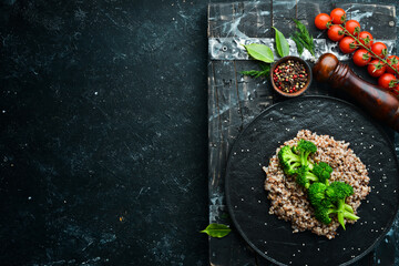 Healthy Diet Food. Boiled buckwheat and broccoli. On a black stone plate. Top view.