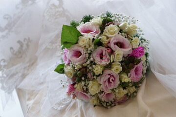Close up of a Colorful wedding bouquet with a white dress background
