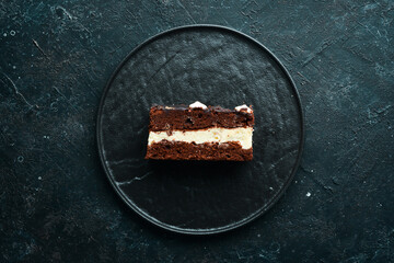 Chocolate cake with creamy mousse filling. Dessert. On a black background. Top view.