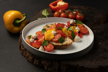 Vegan vegetable salad with bell peppers, cherry tomatoes, basil, capers, sun-dried tomatoes with white bread and peanut sauce..