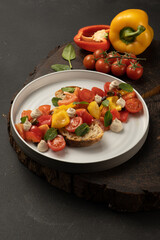 Vegan vegetable salad with bell peppers, cherry tomatoes, basil, capers, sun-dried tomatoes with white bread and peanut sauce..