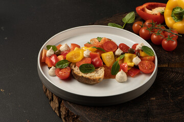Vegan vegetable salad with bell peppers, cherry tomatoes, basil, capers, sun-dried tomatoes with white bread and peanut sauce..