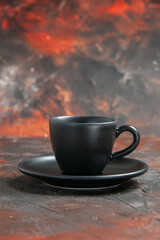 front view black cup and saucer on dark red background