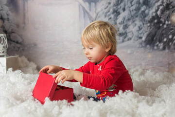 Fototapeta premium Cute blond toddler child, playing with snow and christmas decoration