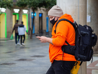 Hombre con ropa de invierno usando su móvil 