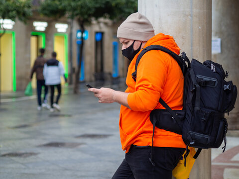 Hombre con ropa de invierno usando su m&oacute;vil 