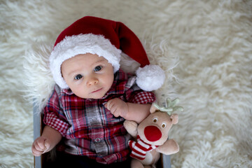 Christmas portrait of cute little newborn baby boy, dressed in christmas clothes