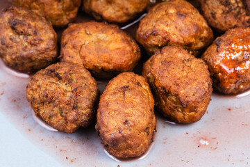 cooked swedish meatballs with lingonberry sauce on blue plate close up