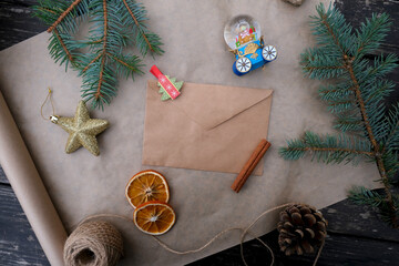 On a wooden table there is an envelope and a New Year's composition. 