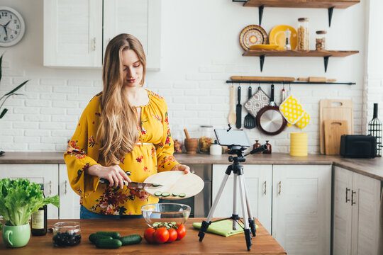 Pregnant girl blogger shoots a video of a salad recipe on a smartphone camera