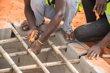 Construction workers busy with construction of septic pit, wearing personal protective equipment