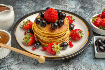 front view yummy pancakes with fresh fruits and honey on light background fruit cake sweet