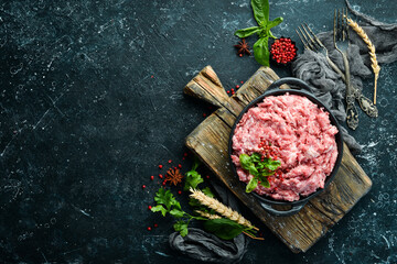 Minced pork in a bowl with spices. Top view. Rustic style.