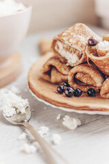 pancakes with curd filling and black currants on a plate