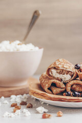 cottage cheese in a bowl and pancakes with curd filling