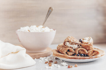 cottage cheese in a bowl and pancakes with curd filling