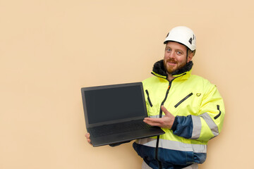 Male industrial worker in hard hat with laptop. Bearded engineer with white hard hat helmet working on laptop computer. Climber