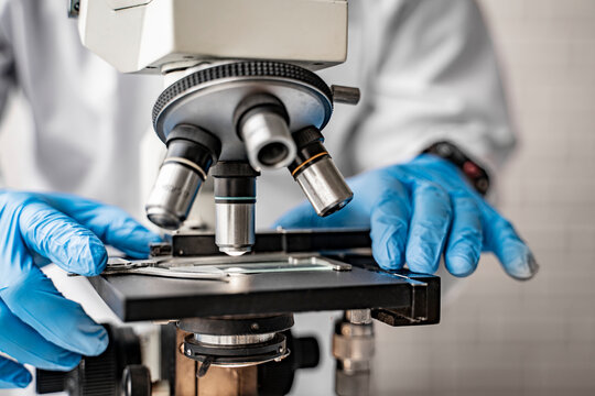 Doctor Wearing Protective Gloves Using Microscope Researching Corona Virus Microscopic Cells Testing Vaccination Cure, Medical Center Lab China Wuhan World Health Organization Research Facilities