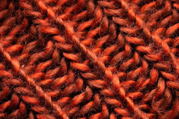 Red-orange knitted background texture. Close-up of knitted stitches. Macro