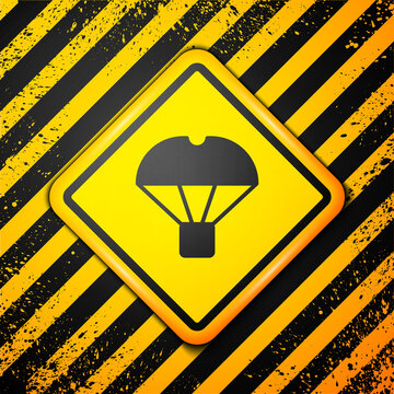 Black Box Flying On Parachute Icon Isolated On Yellow Background. Parcel With Parachute For Shipping. Delivery Service, Air Shipping. Warning Sign. Vector.