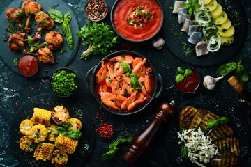 Set meal of meat, seafood and vegetables on the black stone table. Top view. Free space for your text.