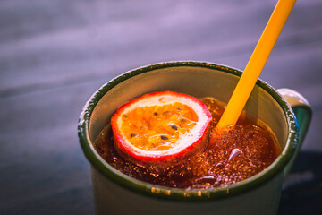 a passionfruit drink with ice in a metal tumbler on a table