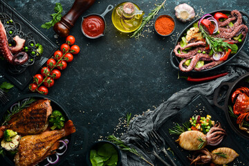 Set of seafood dishes. Fish, squid, octopus on a black stone background. Top view. Free space for your text.