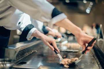 Hand of man take cooking of meat with vegetable grill, Chef cooking wagyu beef in Japanese teppanyaki restaurant