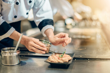 Hand of man take cooking of meat with vegetable grill, Chef cooking wagyu beef in Japanese teppanyaki restaurant