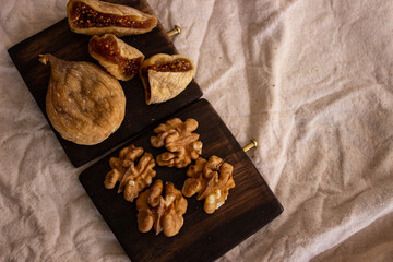 top view, walnuts and dried figs on the wooden plate for diet food, space for text.