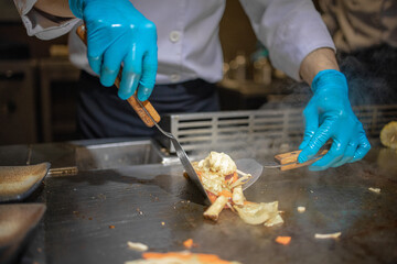 Hand of man take cooking of meat with vegetable grill, Chef cooking wagyu beef in Japanese teppanyaki restaurant