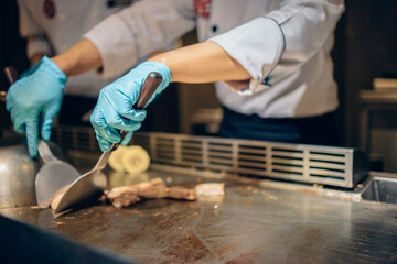 Hand of man take cooking of meat with vegetable grill, Chef cooking wagyu beef in Japanese teppanyaki restaurant