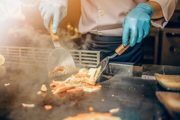 Hand of man take cooking of meat with vegetable grill, Chef cooking wagyu beef in Japanese teppanyaki restaurant