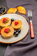 front view yummy pancakes with fruits and olives on a dark background sweet fruit cake