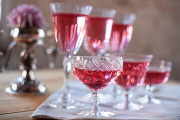 crystal glasses with rose wine, flowers on a wooden table. Wedding decoration