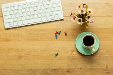 desktop : keyboard and cup coffee with flowers pot  