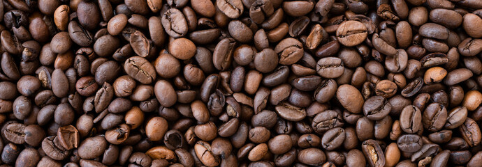 Flat lay with copy space, close-up view of some roasted coffee beans forming a natural pattern. Natural background.