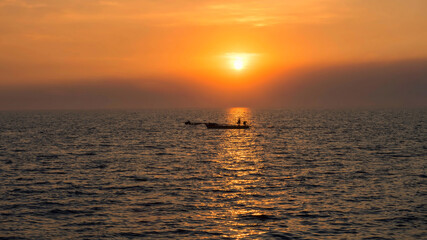 Silhouette fisherman on fishing boat at sunset, Bang Pu