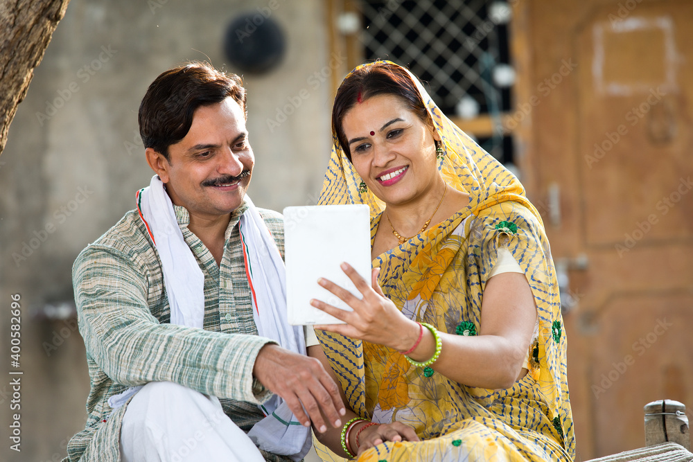 Wall mural Rural Indian wife and husband using digital tablet at village