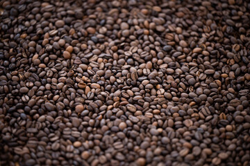 Flat lay with copy space, close-up view of some roasted coffee beans forming a natural pattern. Natural background.