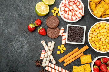 Fototapeta na wymiar top view fresh strawberries with different snacks on dark background fruit biscuit sweet