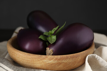 Ripe purple eggplants and basil on table, closeup