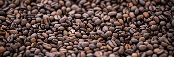 Flat lay with copy space, close-up view of some roasted coffee beans forming a natural pattern. Natural background.