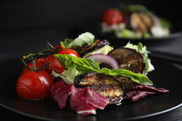 Delicious salad with roasted eggplant and basil on plate, closeup