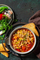 Traditional mexican food. Chili con carne, minced meat with vegetables on dark stone table. Top view flat lay. Copy space.