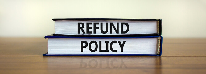 Refund policy symbol. Books with words 'Refund policy' on beautiful wooden table. White background....